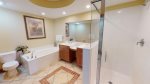 Bathroom has a large, jetted tub along with a separate shower stall, and dual sink basins